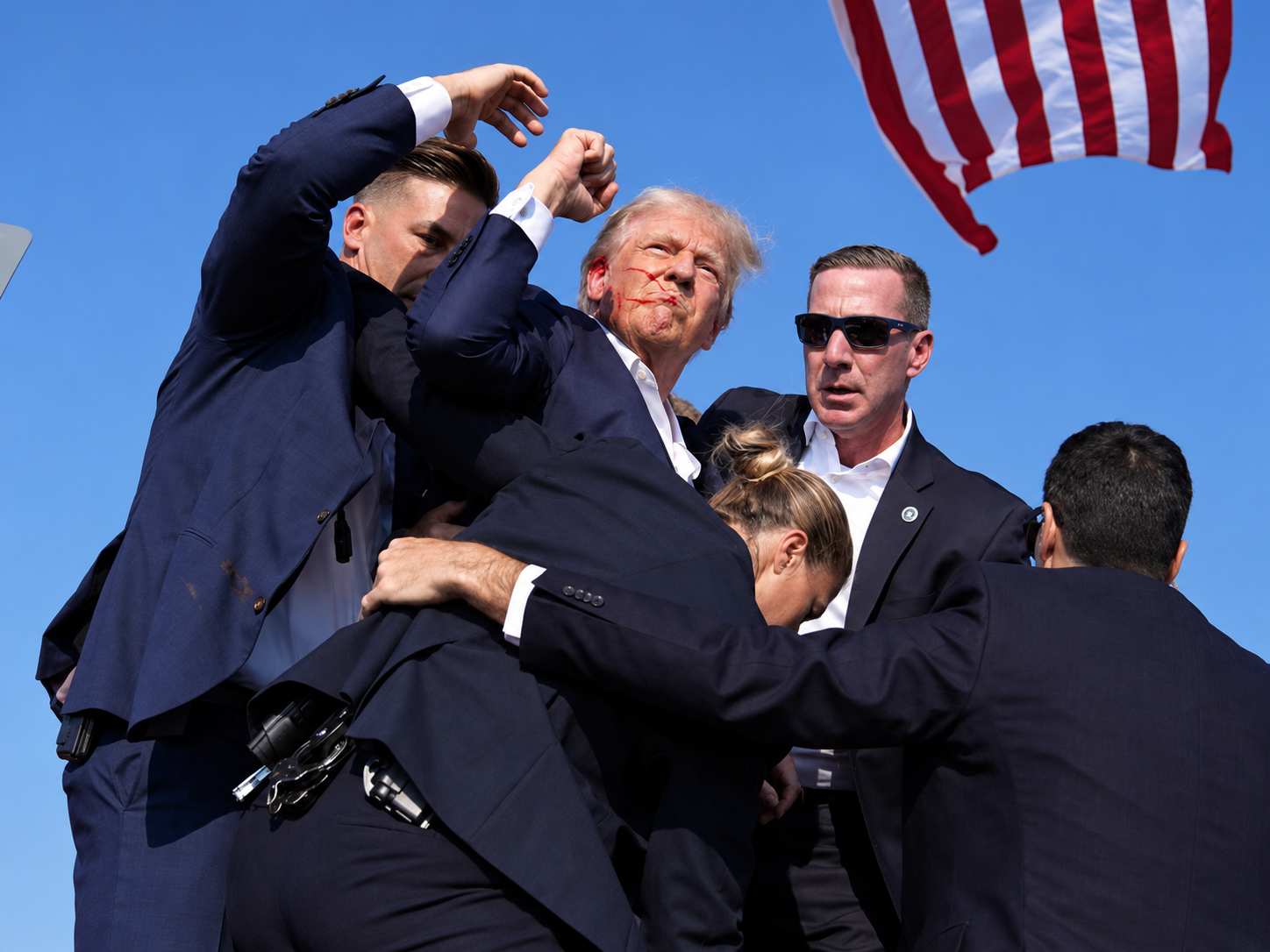 Donald Trump surrounded by Secret Service agents after an assassination attempt at a campaign rally