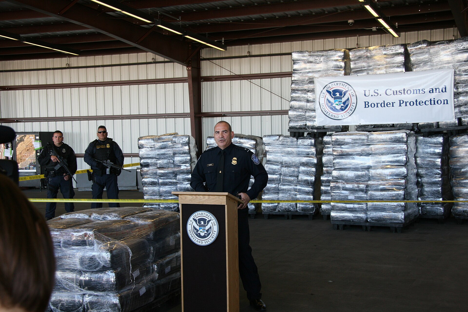 U.S. Customs and Border Protection officials stand beside seven tons of seized marijuana.